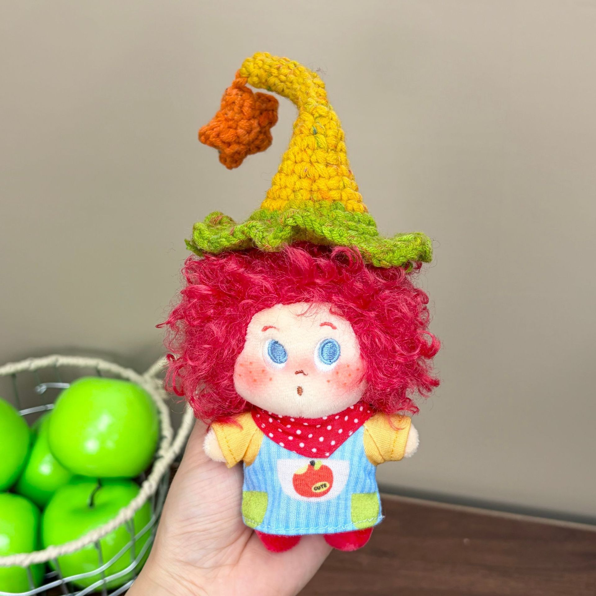Supplied product photograph: red curly-haired doll with a star-topped pointed hat. Style reference 2; outfit and hat details vary.