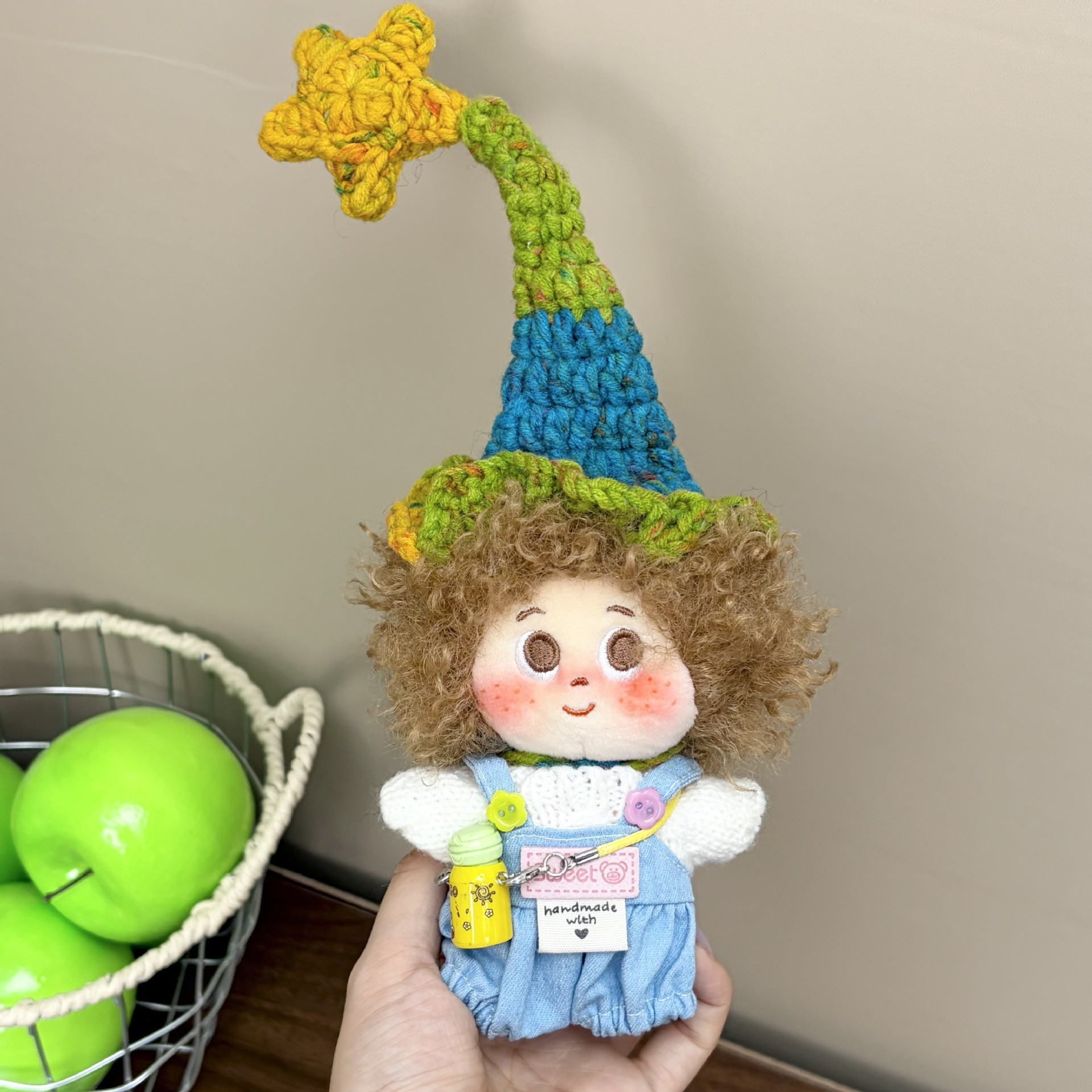 Supplied product photograph: sandy curly-haired doll with a star-topped pointed hat. Style reference 3; outfit and hat details vary.