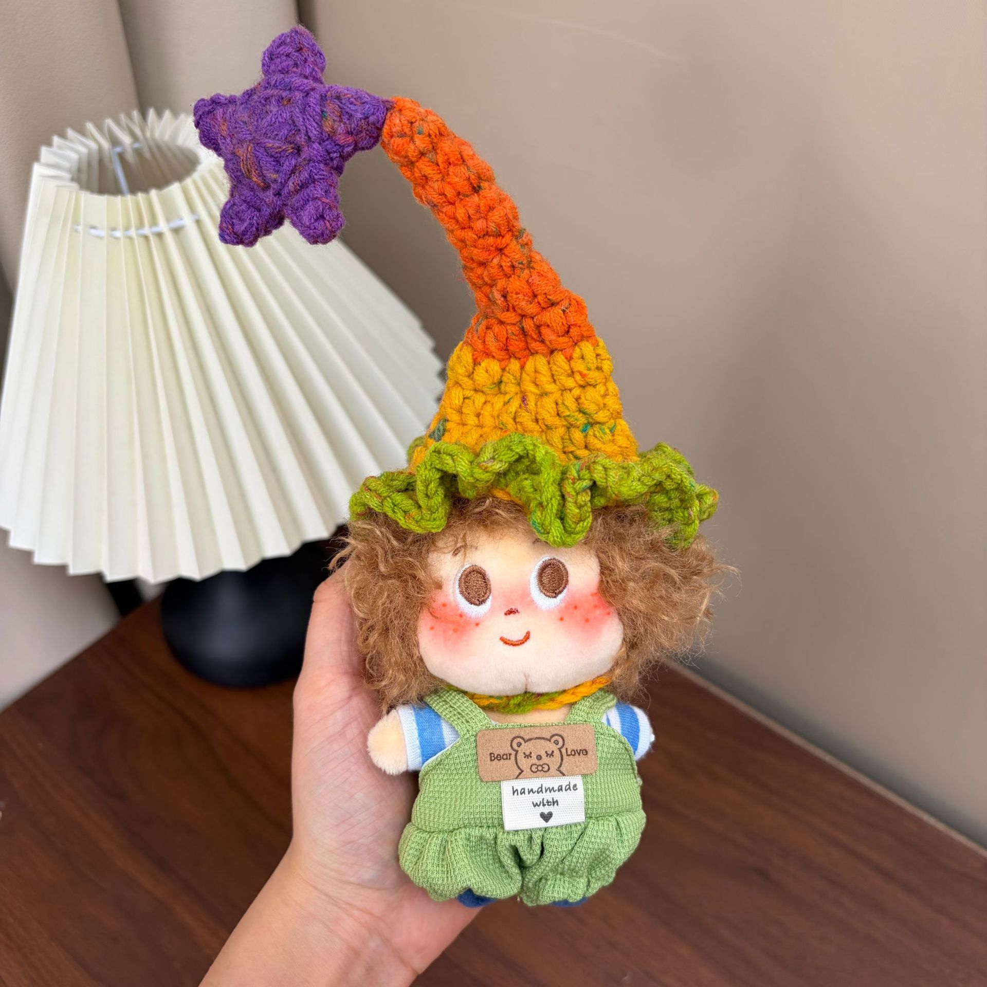 Supplied product photograph: sandy curly-haired doll with a star-topped pointed hat. Style reference 4; outfit and hat details vary.