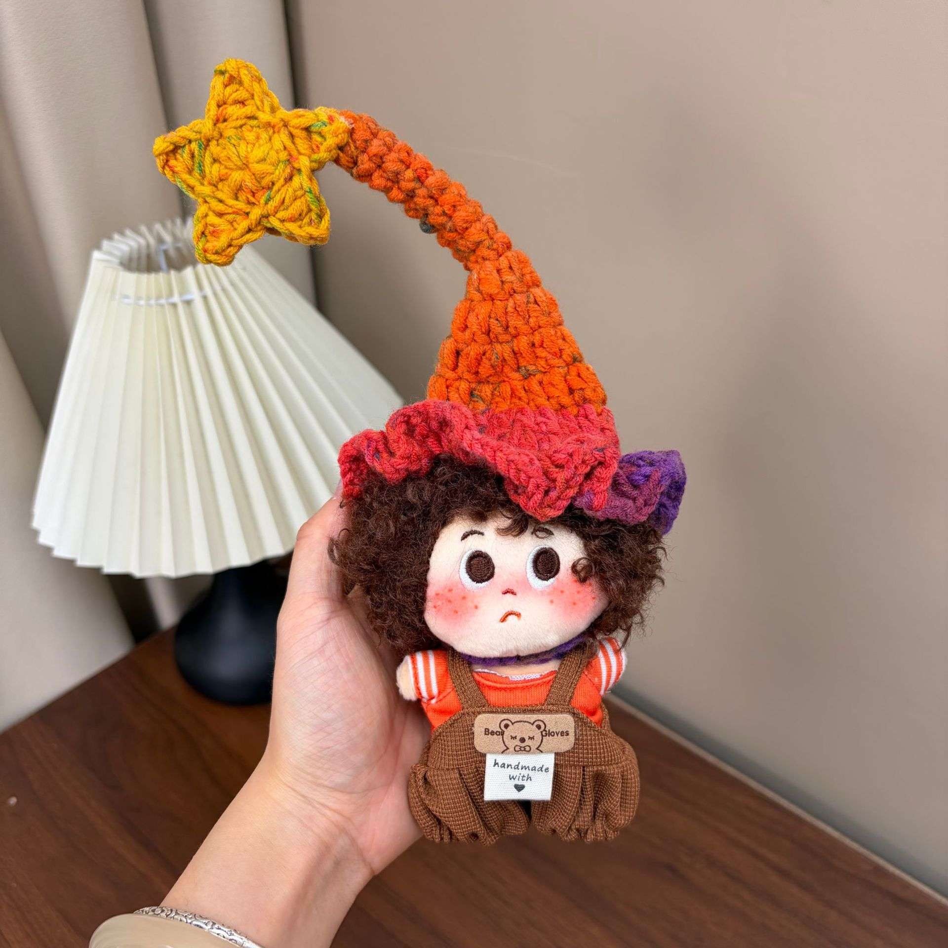 Supplied product photograph: brunette curly-haired doll with a star-topped pointed hat. Style reference 1; outfit and hat details vary.